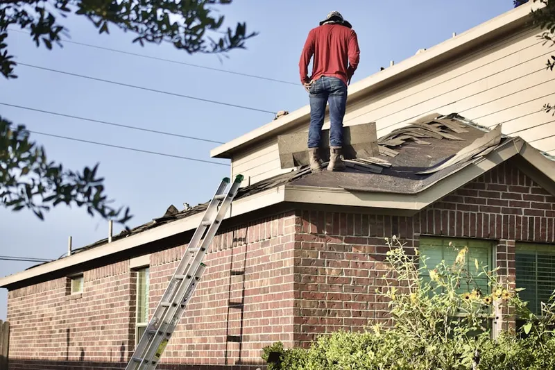 Professional roofer working on a residential roof in Breton Woods